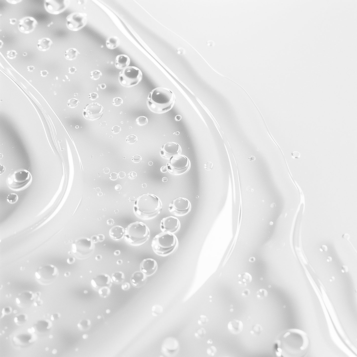 A transparent liquid with air bubbles on a smooth white surface forms abstract, wavy patterns. Its simplicity and clarity echo the serene, minimalistic aesthetic of 111 & Company 10% Niacinamide Serum.