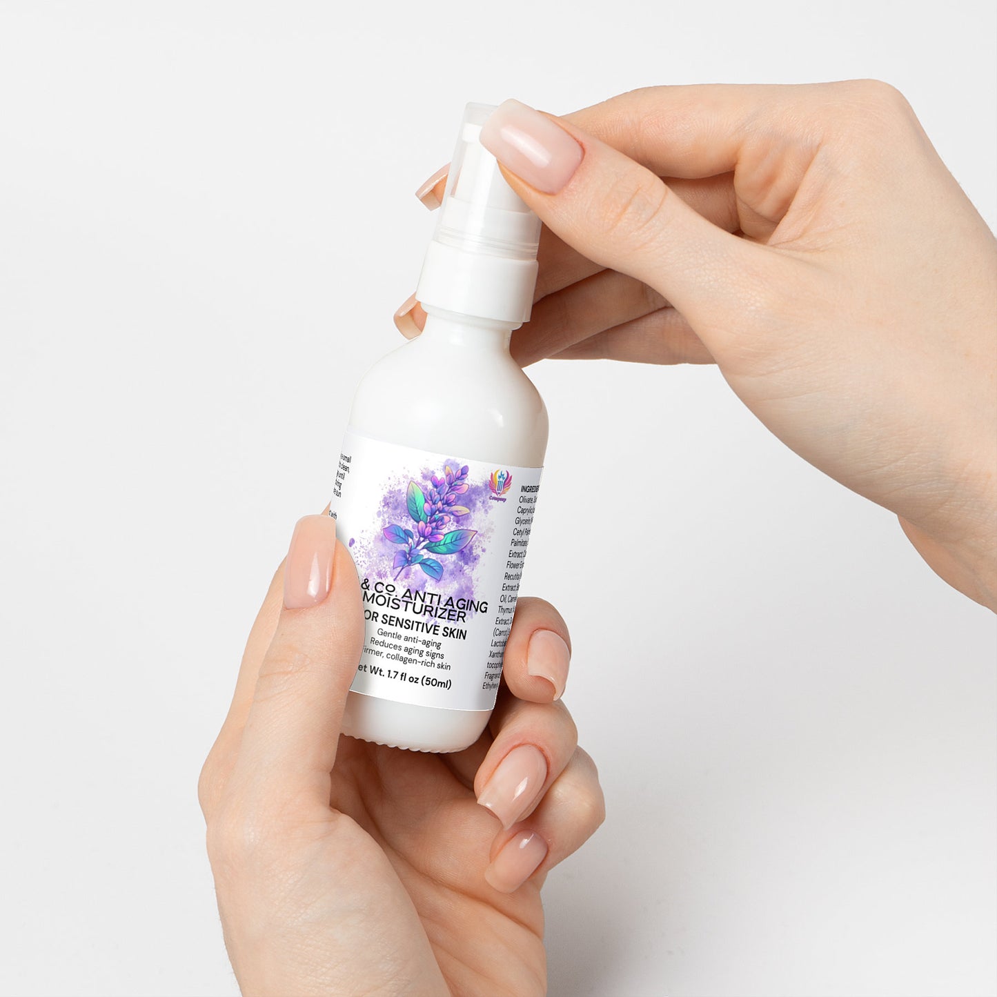 A person with neatly manicured nails holds a white spray bottle featuring a purple floral design. The label says 111 & Co. ANTI AGING MOISTURIZER FOR SENSITIVE SKIN by 111 & Company highlighting skin elasticity and collagen production. It contains 2 fl oz (59 ml) against an off-white background.