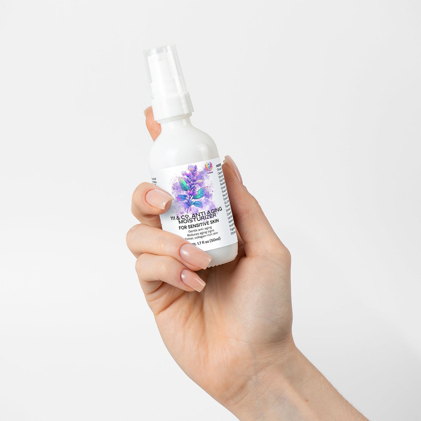 A manicured hand holds a white spray bottle labeled 111 & Co. Anti Aging Moisturizer for Sensitive Skin. The label shows purple flowers and green leaves, suggesting benefits for skin elasticity. The background is plain white.