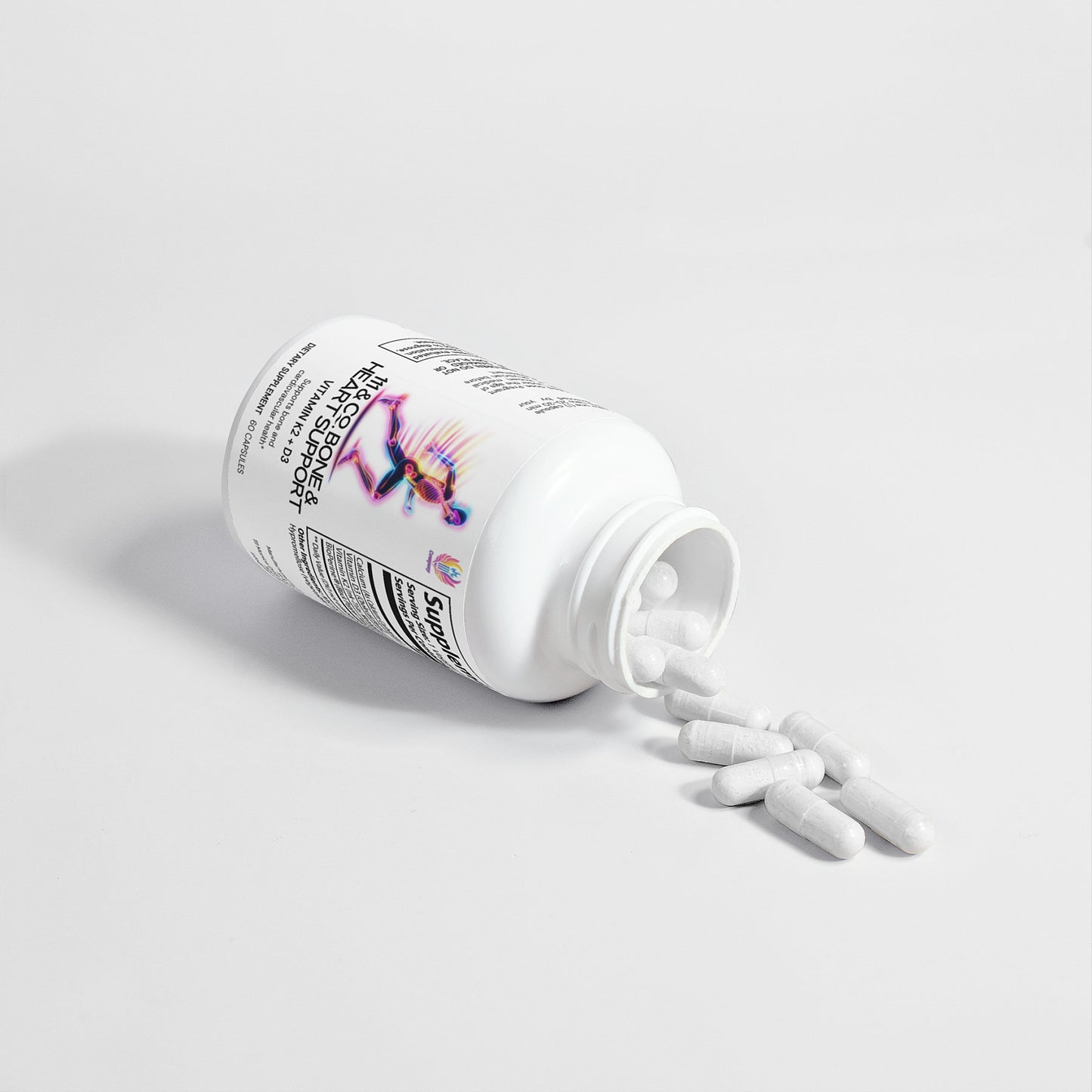 A white plastic bottle of 111 & COMPANY BONE & HEART SUPPORT lies on its side, spilling capsules onto a light surface. The label features text and an abstract colorful design with small print promoting bone health benefits, emphasizing the bottle and capsules minimal composition.