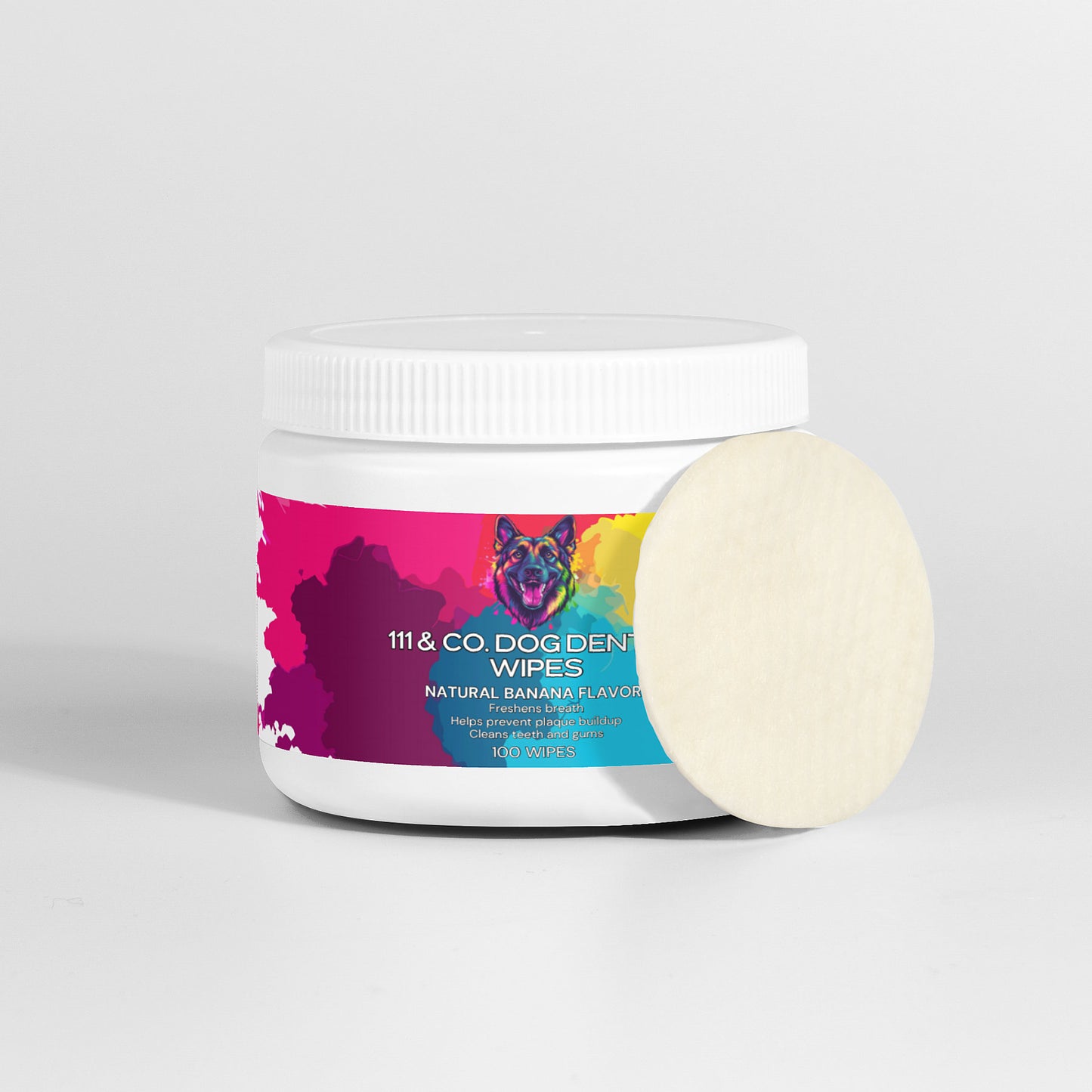 A white cylindrical container labeled 111 & Company Dog Dental Wipes with natural banana flavor and enzymes, aimed at reducing plaque for effective dog teeth cleaning, features a colorful dog illustration on the label and a single round wipe leaning against it on a plain gray background.