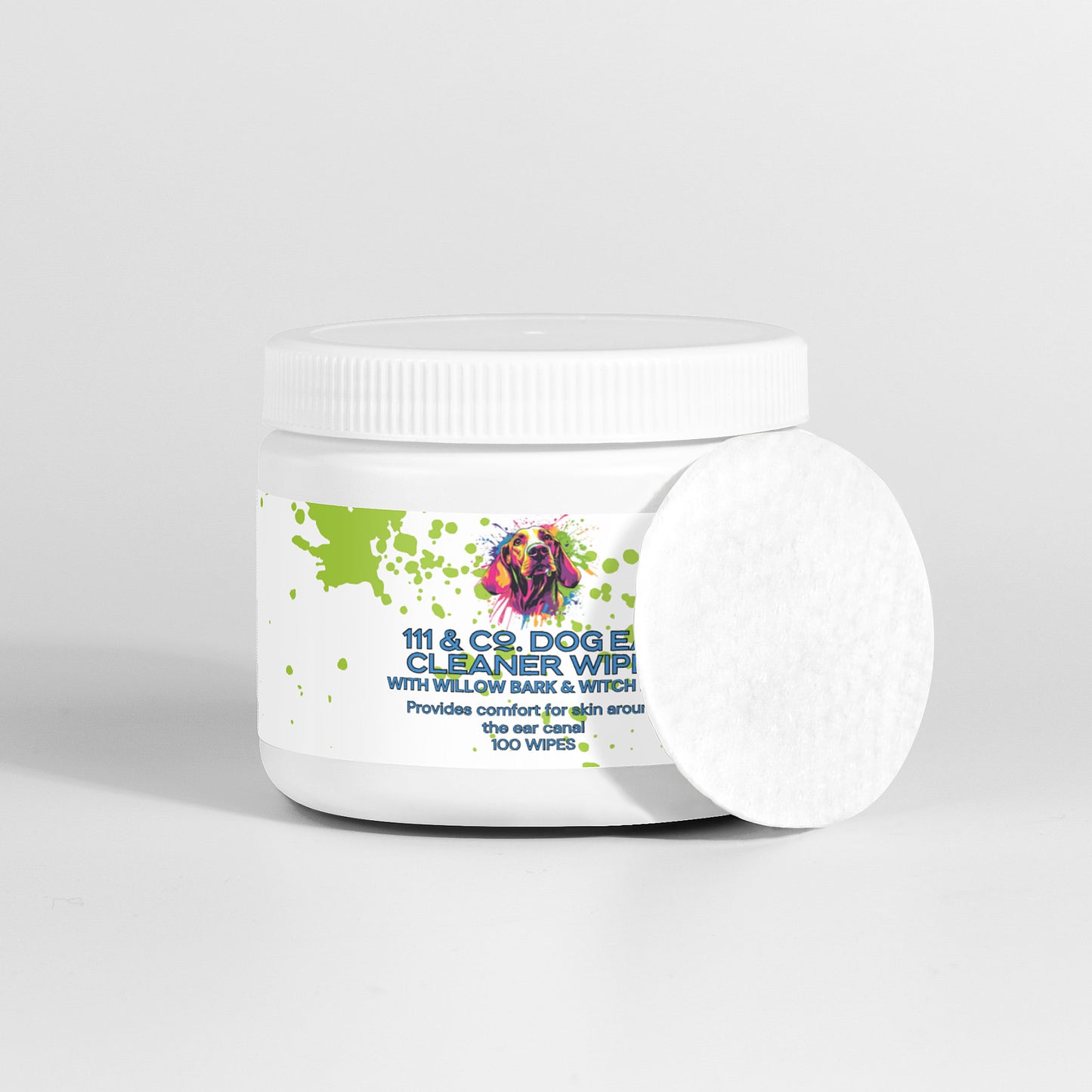A white jar of 111 & Company Dog Ear Cleaner Wipes with a lid, featuring a colorful dog illustration and green splatter design, ideal for dogs with floppy ears. The label reads, “Dog Ear Cleaner Wipes with Willow Bark & Witch.” A single round white wipe leans against the jar. Contains 100 natural ingredient wipes.