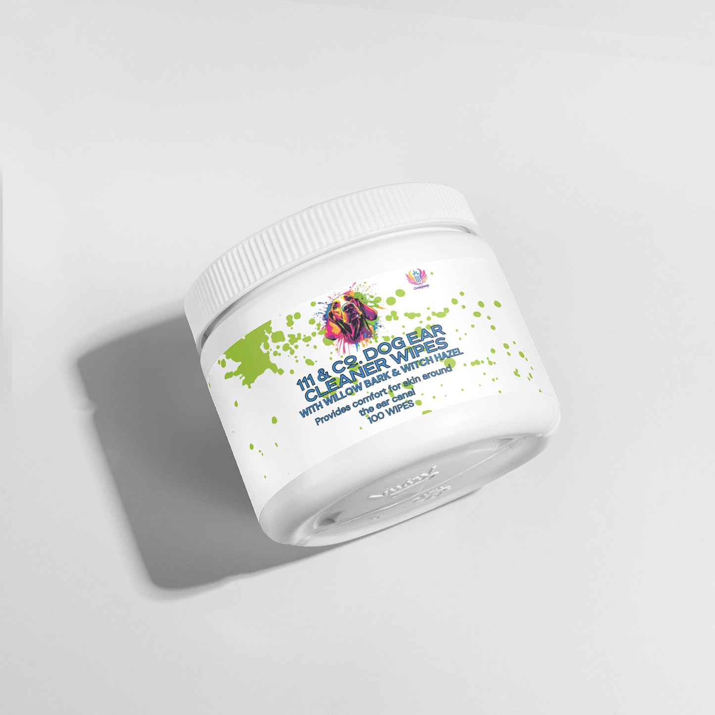 A white cylindrical container of 111 & Company Dog Ear Cleaner Wipes with a green splatter design is slightly tilted, casting a shadow on a light gray surface. The label features a colorful dog graphic and emphasizes natural ingredients like aloe and witch hazel for effective cleaning.