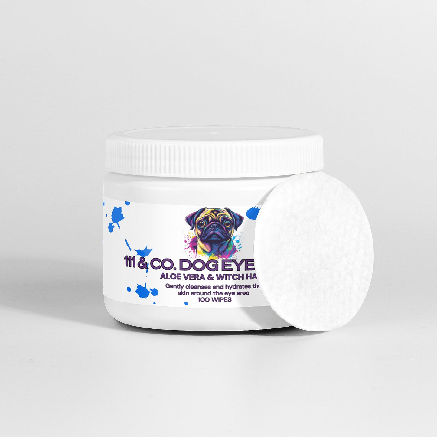A white container of 111 & COMPANY DOG EYE WIPES with natural ingredients like aloe vera and witch hazel features a colorful dog illustration on the label, perfect for tear stain removal. The lid is white, and one round cotton wipe leans against the packaging, indicating 100 wipes.
