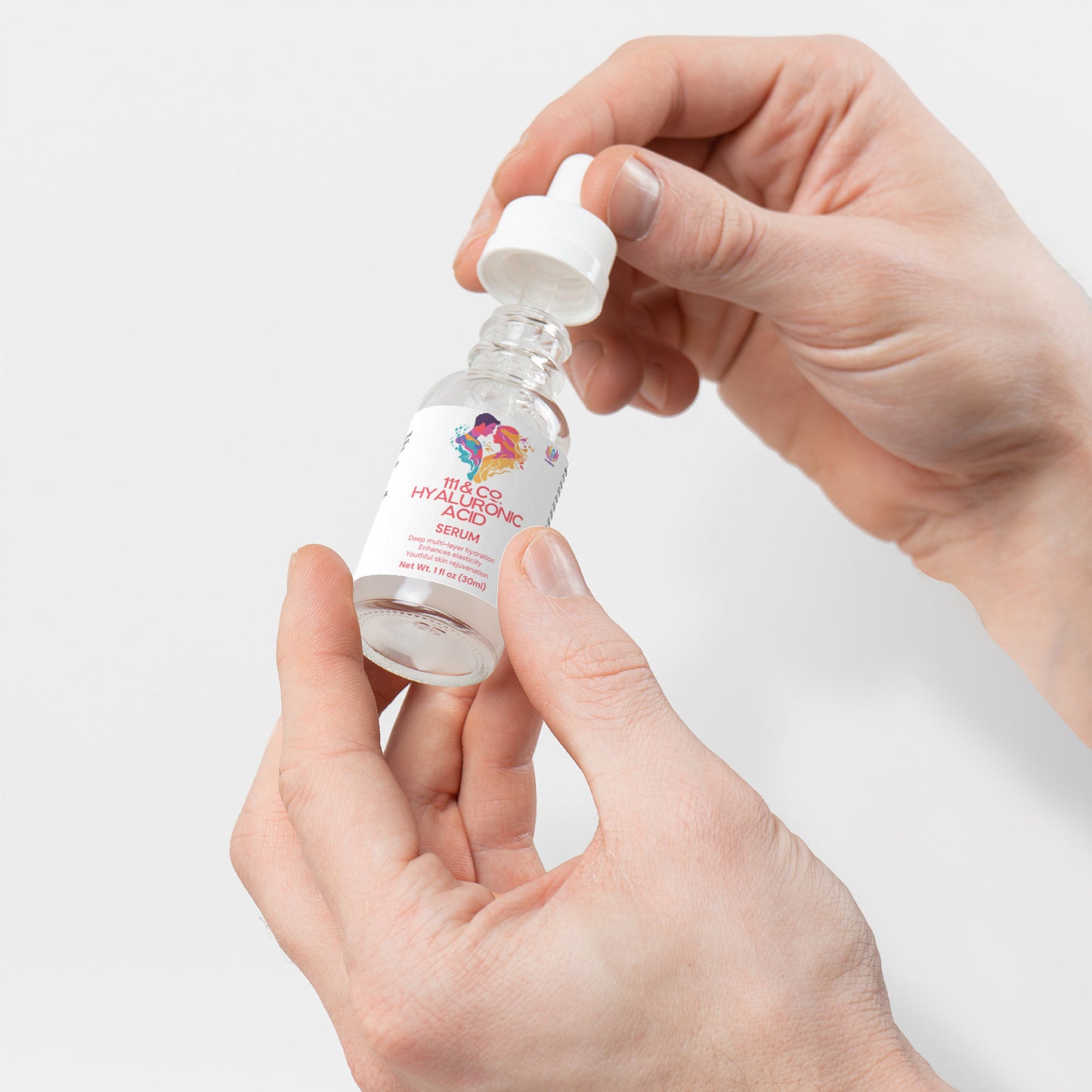 Hands delicately hold the 111 & COMPANY HYALURONIC ACID SERUM, set against a white backdrop. The poised hands emphasize its promise of rejuvenation and deep hydration, showcasing the serums transformative power for achieving radiant skin.