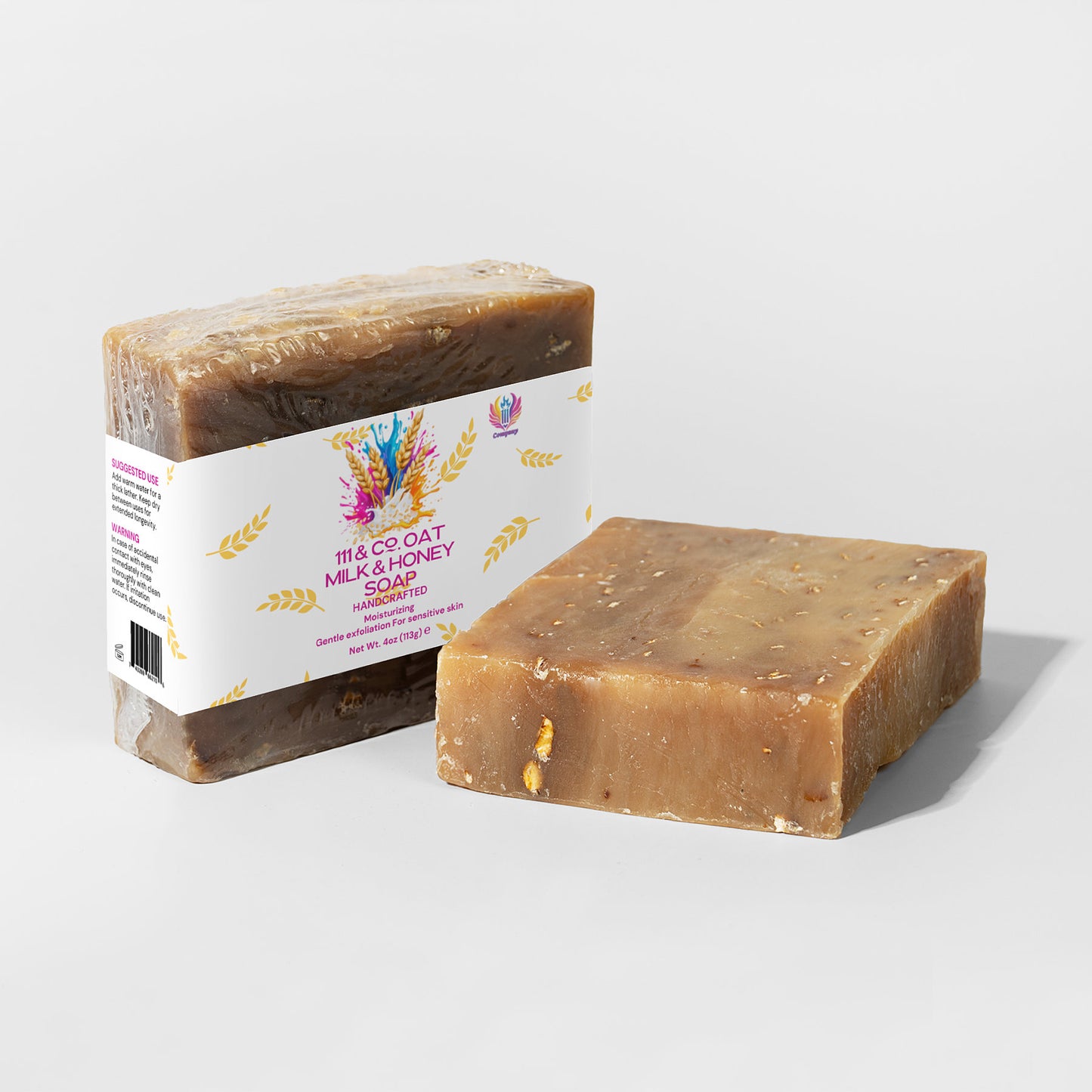 Two bars of 111 & COMPANY OAT MILK HONEY SOAP from 111 & Company are displayed. One stands upright with oat and honey imagery, labeled Milk & Honey Soap. The other lies flat, showcasing a textured surface with visible oats for a nourishing formula ideal for sensitive skin.
