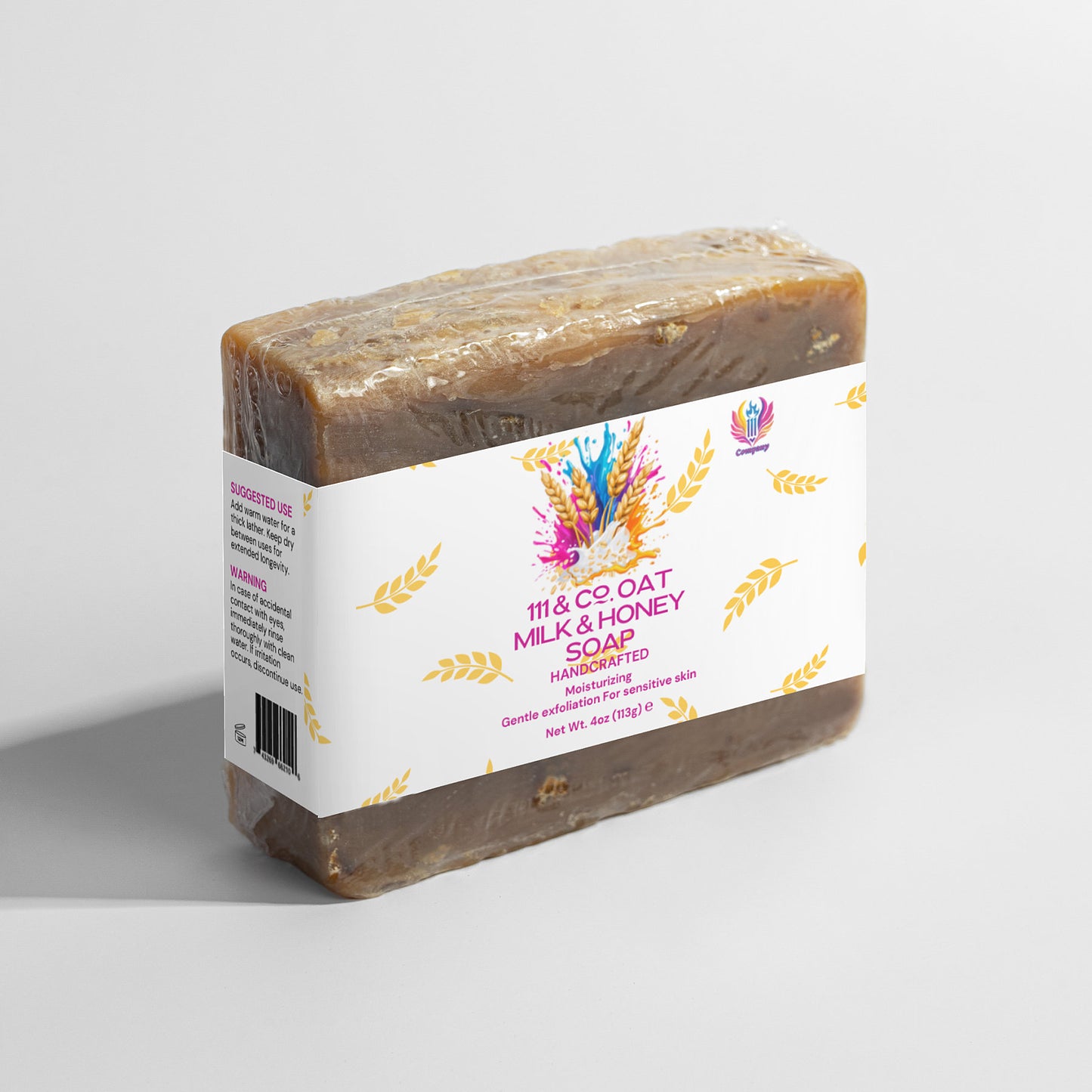 A bar of 111 & COMPANY OAT MILK HONEY SOAP from 111 & Company is in transparent plastic with a white label showcasing colorful designs, text, and wheat graphics. It reads Milk & Honey Soap, highlighting its nourishing oat and honey formula with use suggestions for gentle exfoliation.