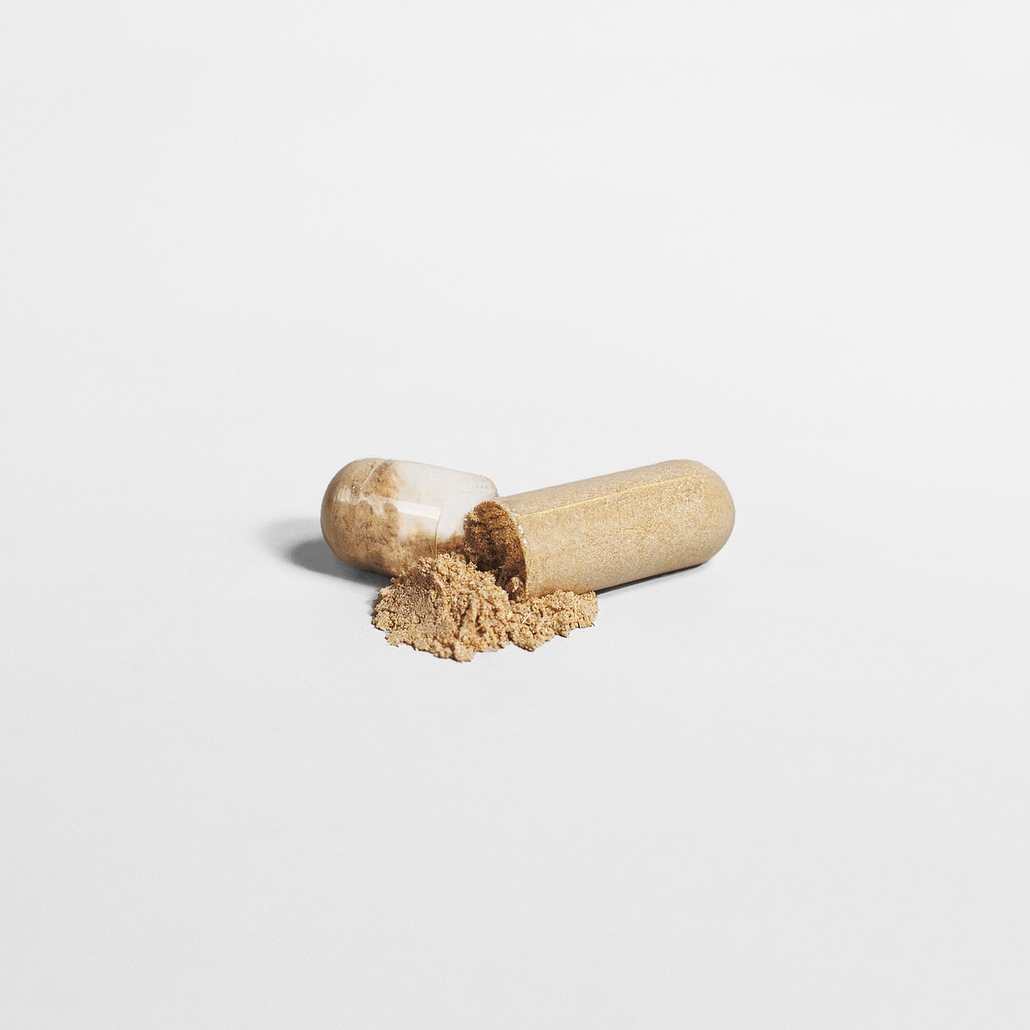 A 111 & COMPANY SLEEP FORMULA 111 & Company spills light brown Valerian Extract onto a white background. The transparent shell reveals the natural sleep formula, centrally placed to highlight its texture and minimalist design.