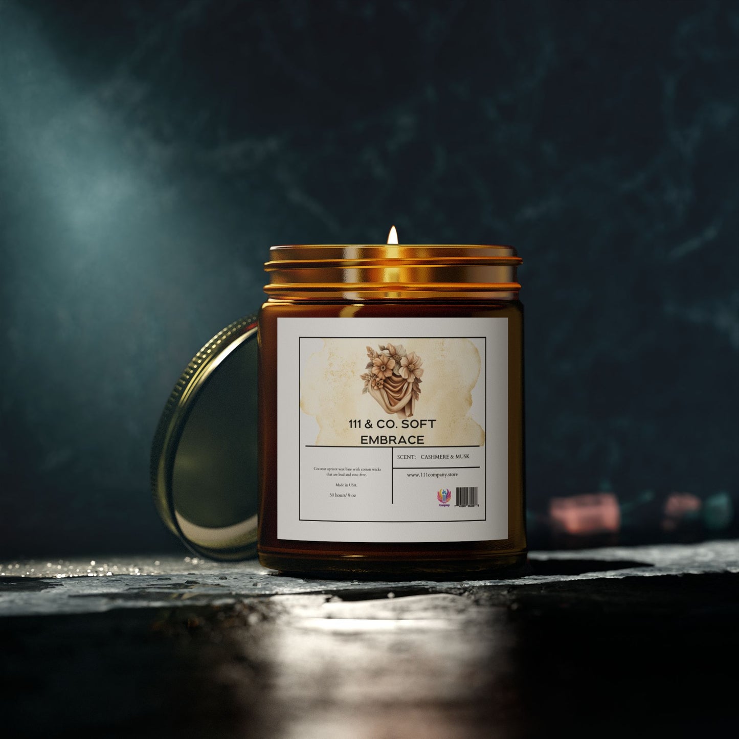 The 111 & COMPANY Soft Embrace cashmere musk candle by 111 & Company features a floral label on its amber glass jar with a metal lid. Made from eco-friendly coconut apricot wax, this 9oz candle creates a cozy atmosphere and comes in a reusable vessel.