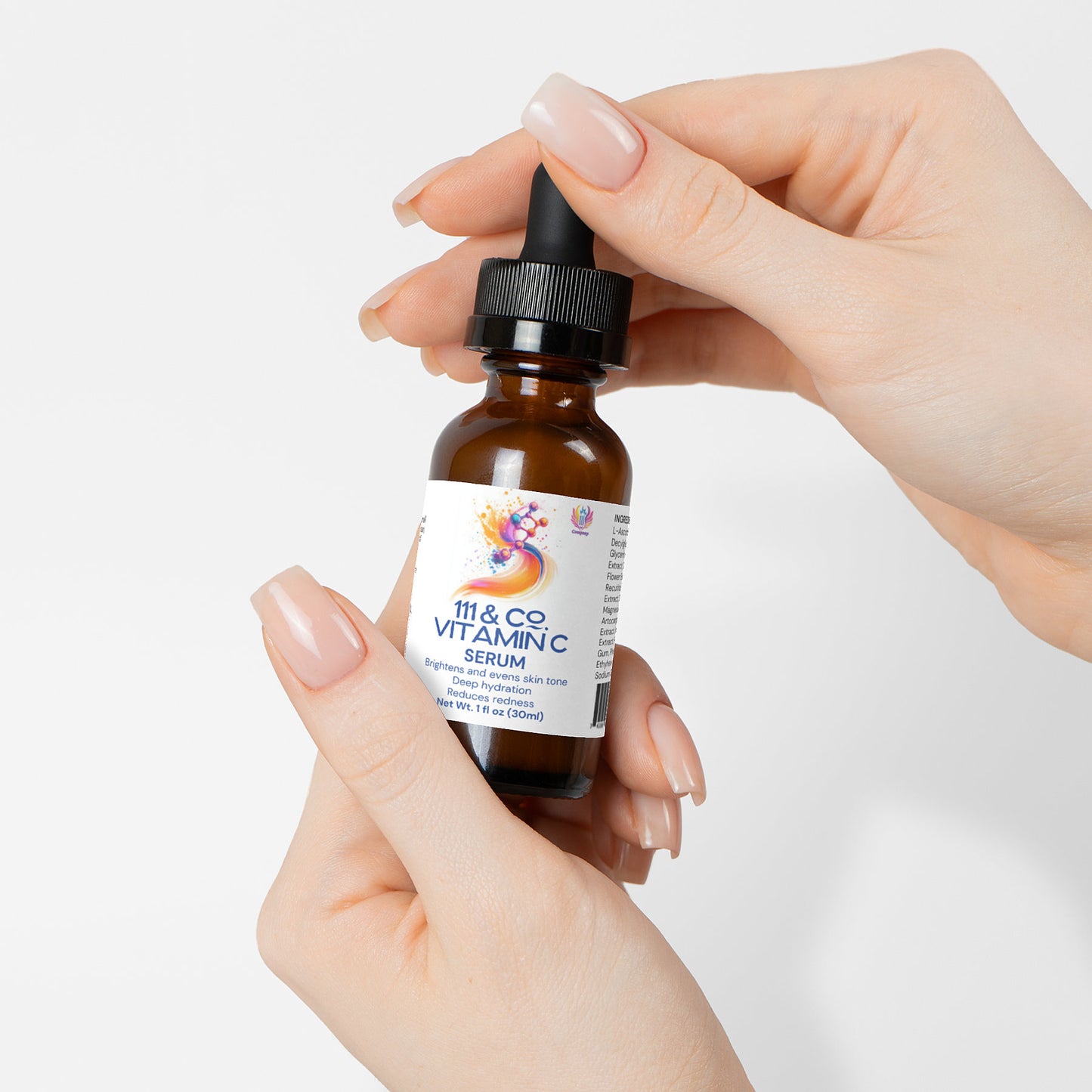 Manicured hands hold a brown glass dropper labeled 111 & COMPANY VITAMIN C SERUM by 111 & Company, featuring colorful graphics. The person is opening the bottle against a plain white background, highlighting its antioxidant and collagen-boosting benefits.