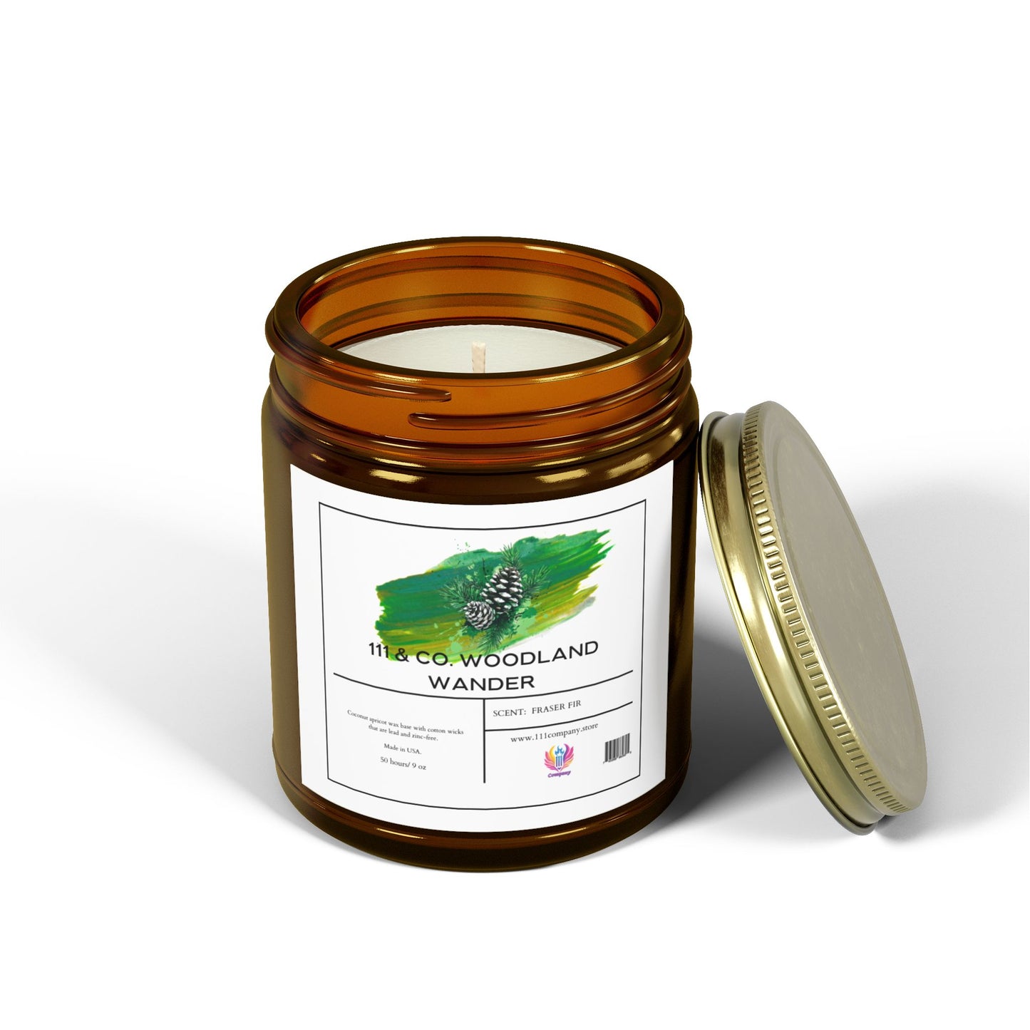 The 111 & Company Woodland Wander Fraser Fir scented candle by 111 & Company, in an amber jar with a green pinecone design, is crafted from a natural coconut apricot wax blend and offers a long burn time. The lid is beside the jar, all set against a white background.