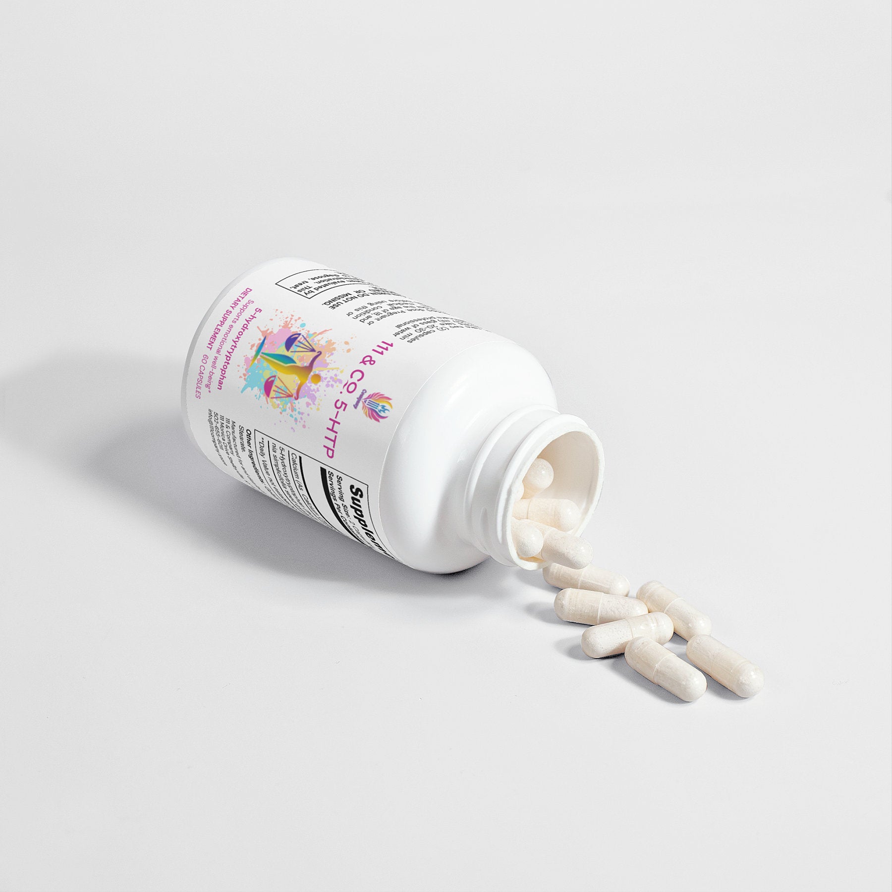 A white 111 & Co. 5-HTP bottle by 111 & Company lies sideways, spilling white capsules onto a light gray surface. Adorned with colorful graphics promoting emotional well-being, its cap is off and more capsules are visible inside. The setting is simple and softly lit.