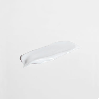 A smooth, white lotion smear of 111 & Co. ANTI AGING MOISTURIZER FOR NORMAL SKIN sits on a plain light gray background. The glossy texture and slightly uneven edges highlight its creamy consistency, designed to boost collagen and enhance skin renewal.