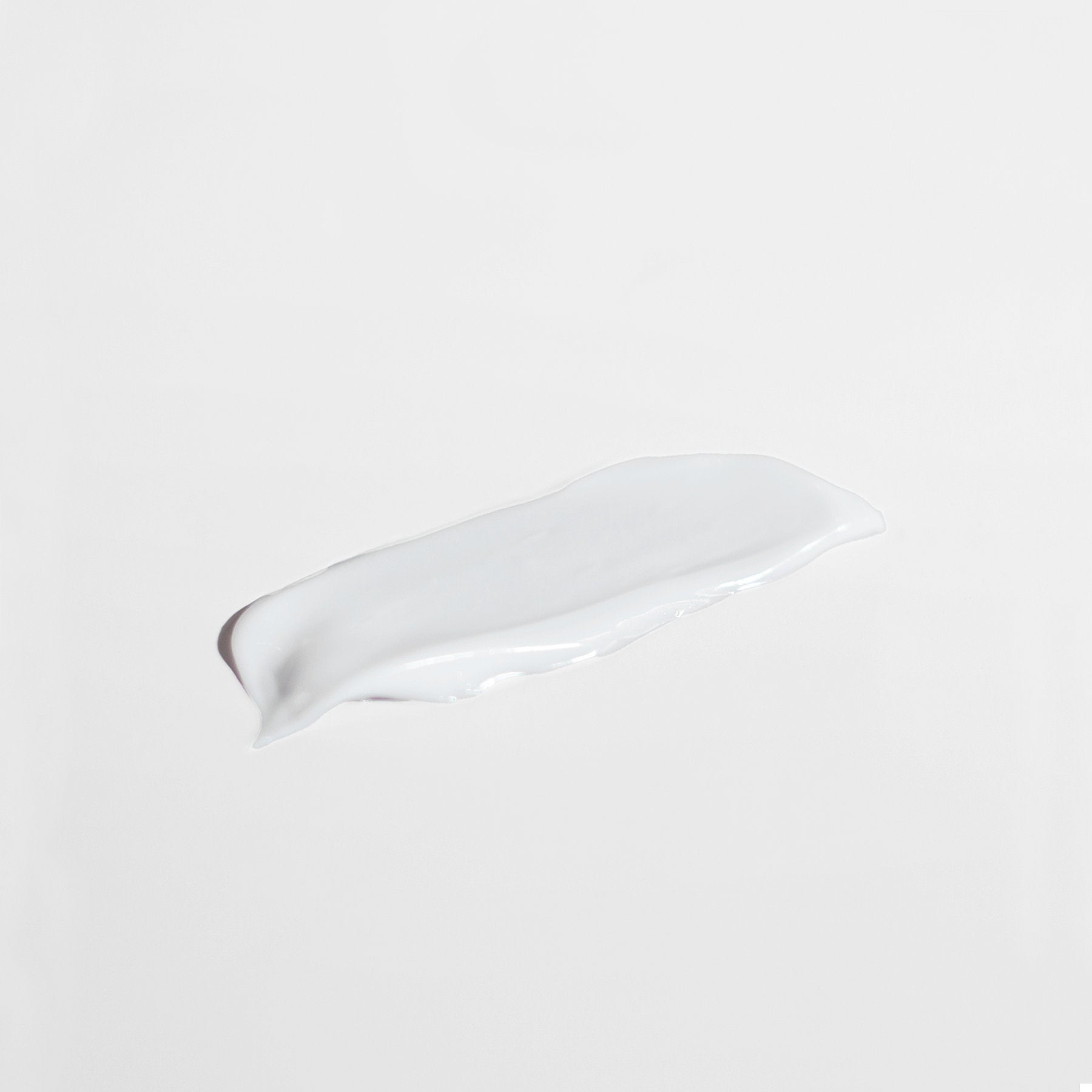 The 111 & Co. Anti Aging Moisturizer for Sensitive Skin by 111 & Company is spread across a white surface, resembling a smooth and creamy anti-aging cream. Its glossy texture with soft edges blends into the minimalist background, hinting at enhanced skin elasticity.