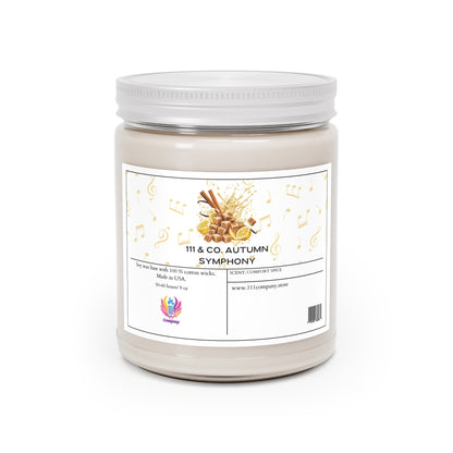The 111 & COMPANY AUTUMN SYMPHONY COMFORT SPICE candle by 111 & Company features musical notes and cinnamon sticks on a white jar, crafted in the USA with soy wax and a cotton wick for a soothing scent. A website URL is displayed at the bottom on a white background.