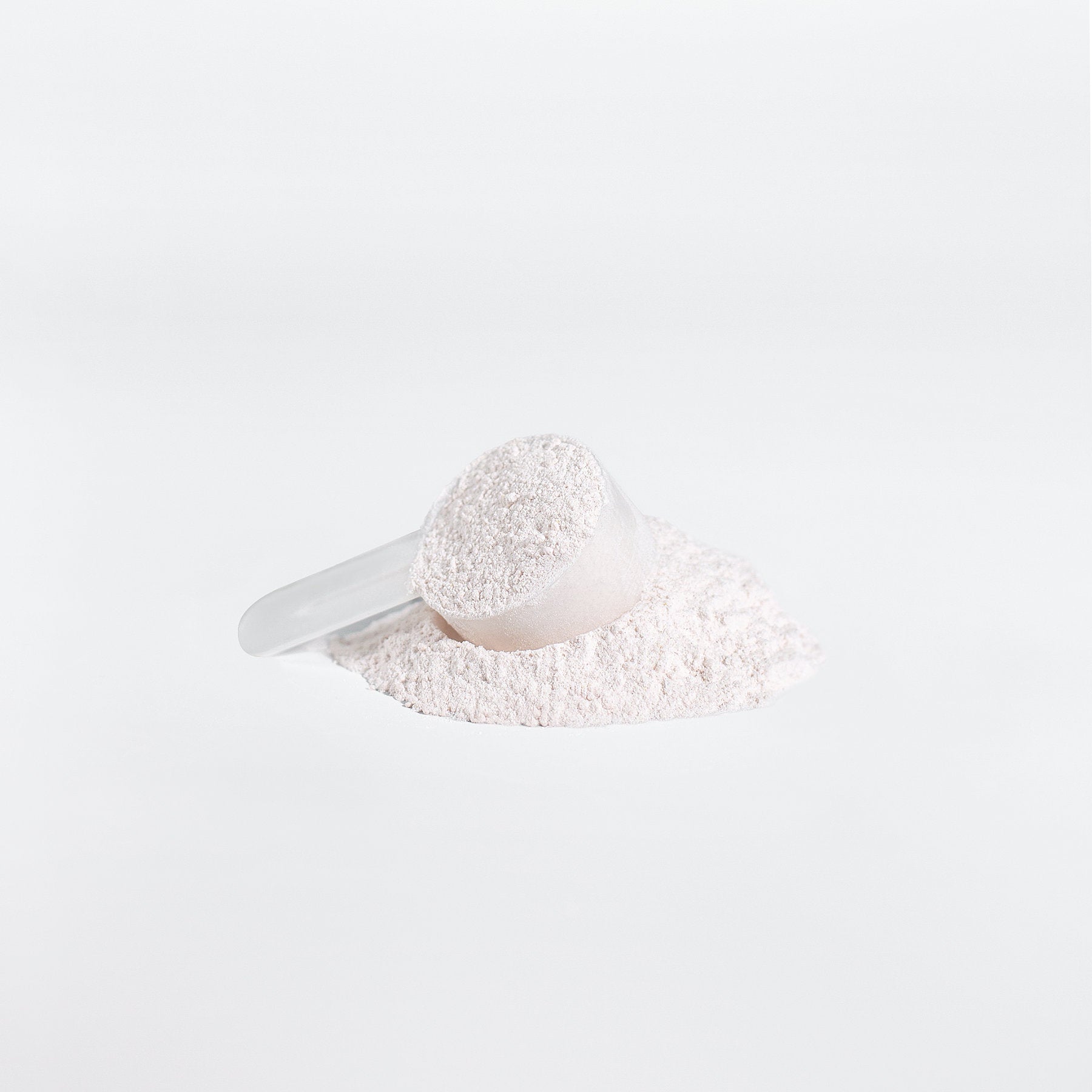A clear scoop of 111 & COMPANY BCAA POST WORKOUT POWDER (HONEYDEW/WATERMELON) from 111 & Company sits on white powder against a pristine backdrop, highlighting amino acids role in muscle recovery. Soft shadows accentuate the minimalist image.