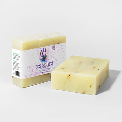Two bars of soap are displayed. The left one is wrapped with a 111 & Company Calming Lavender Soap label featuring purple lavender illustrations, perfect for sensitive skin. The right one is unpackaged, revealing its creamy color speckled with dark flecks against a white background.