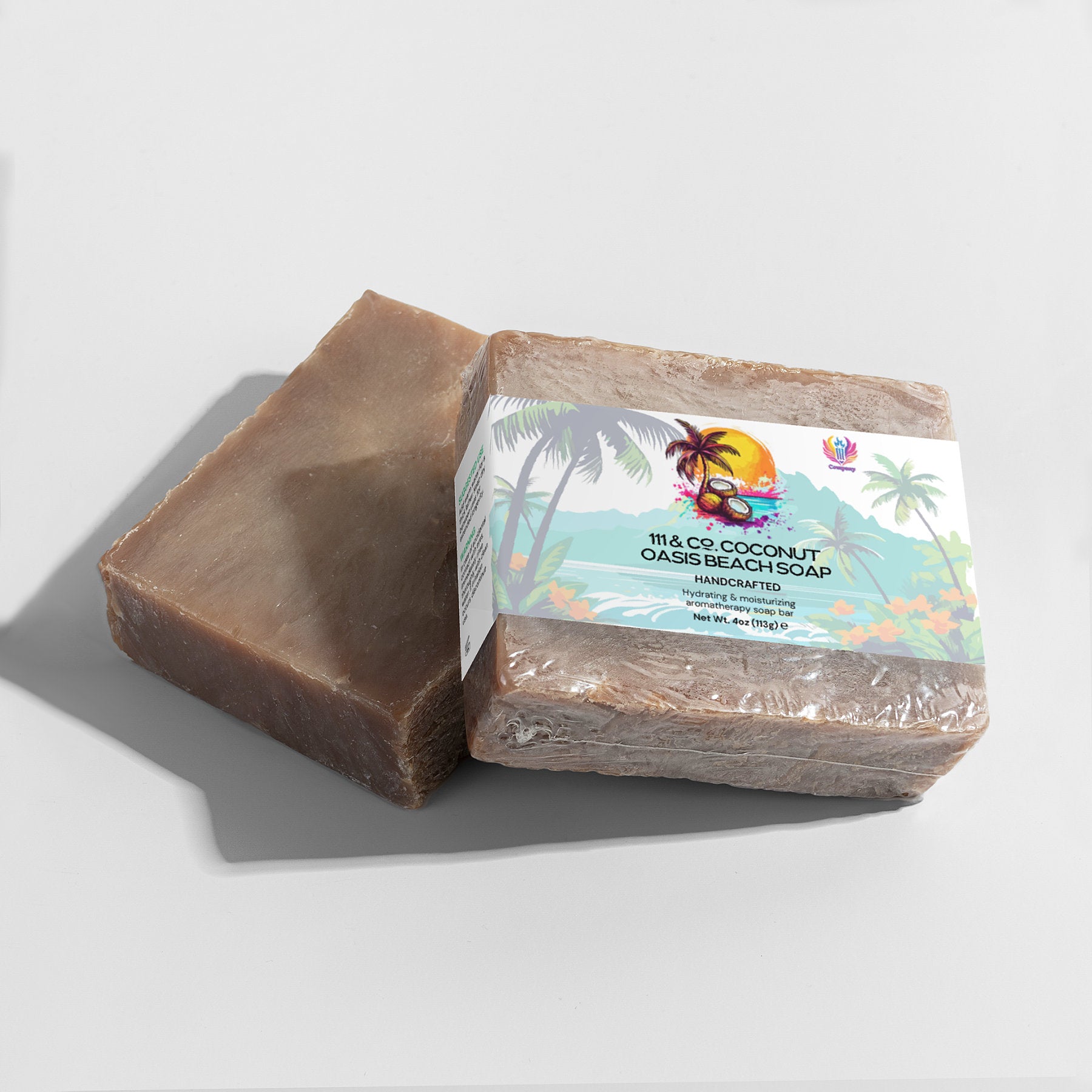 Two rectangular bars of soap from 111 & Company are displayed: one unwrapped, one wrapped with a vibrant beach scene label—palm trees at sunset. It reads 111 & COMPANY COCONUT OASIS BEACH SOAP, perfect for sensitive skin and enriched with organic oils. Shadows fall on a light surface.