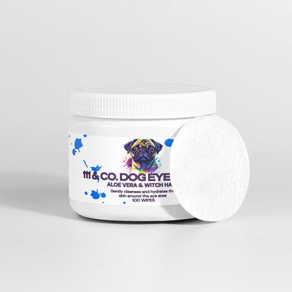 A white container of 111 & COMPANY DOG EYE WIPES with natural ingredients like aloe vera and witch hazel features a colorful dog illustration on the label, perfect for tear stain removal. The lid is white, and one round cotton wipe leans against the packaging, indicating 100 wipes.
