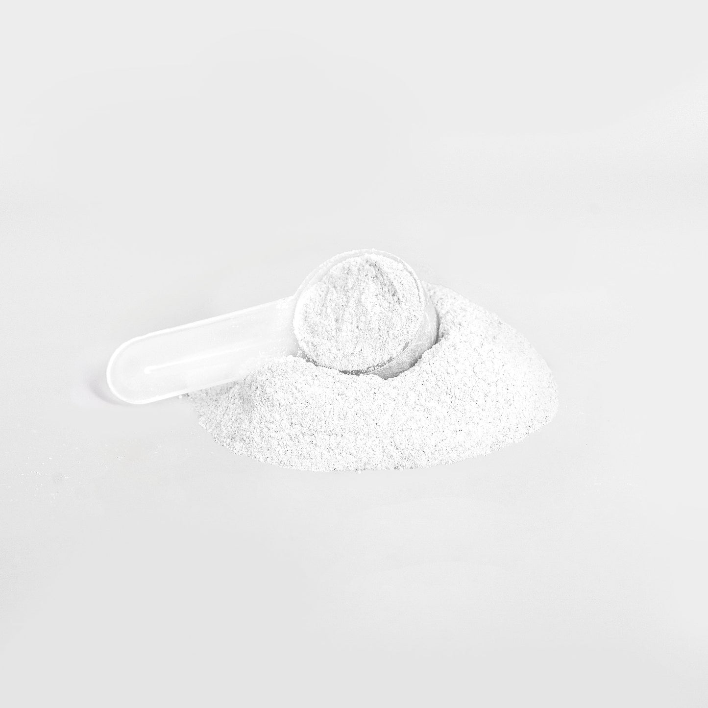 A white plastic scoop rests in a mound of 111 & COMPANY ENERGY POWDER (LYCHEE SPLASH) on a light gray background, filled with sugar-free powder for precise measuring and dispensing.