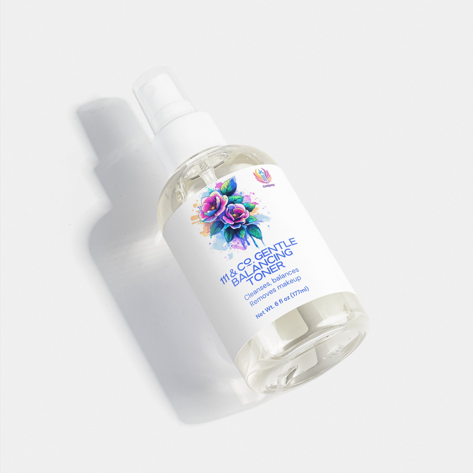 A translucent bottle of 111 & Company Gentle Balancing Toner mist spray rests on a white surface. The label, ideal for sensitive skin, features a vivid watercolor flower design and promises calming balance with net wt. 6 oz (177ml), plus a small pink and blue logo above.