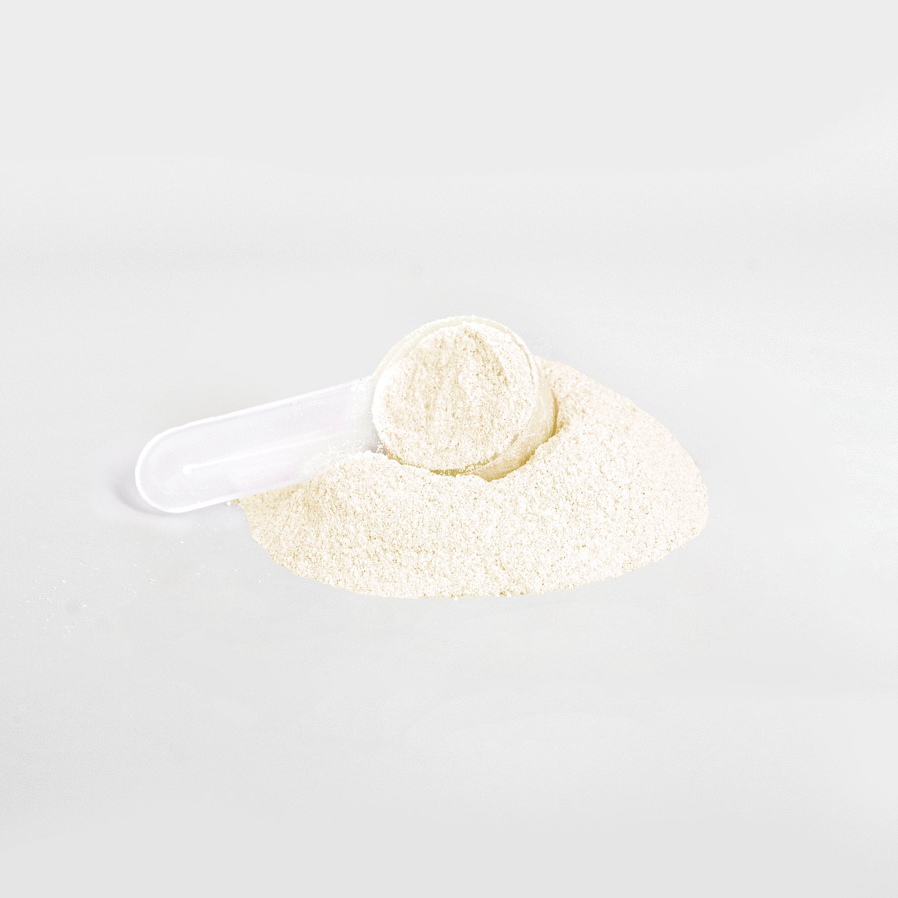 A white plastic scoop sits on a pile of fine, light beige powder against a white background. The scoop is partially filled with the smooth 111 & Company Hydration Powder (Lemonade), providing essential electrolytes for effective keto-friendly hydration.