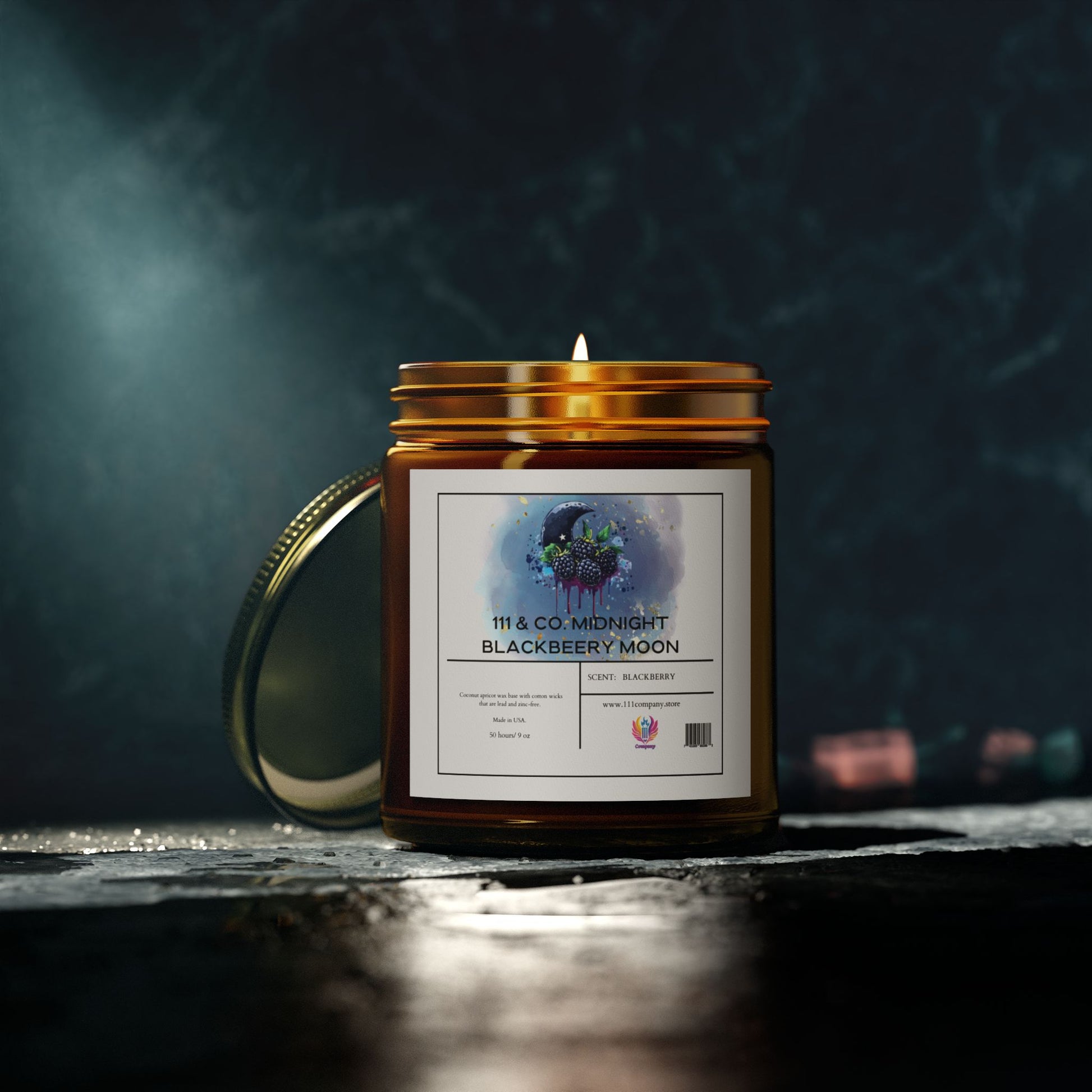 The 9oz  111 & Company Midnight Blackberry Moon Scented Candle in an amber jar casts a warm glow and fruity scent. The moon and tree watercolor label complements its gold lid on a textured dark surface, with blurred lights adding ambiance.