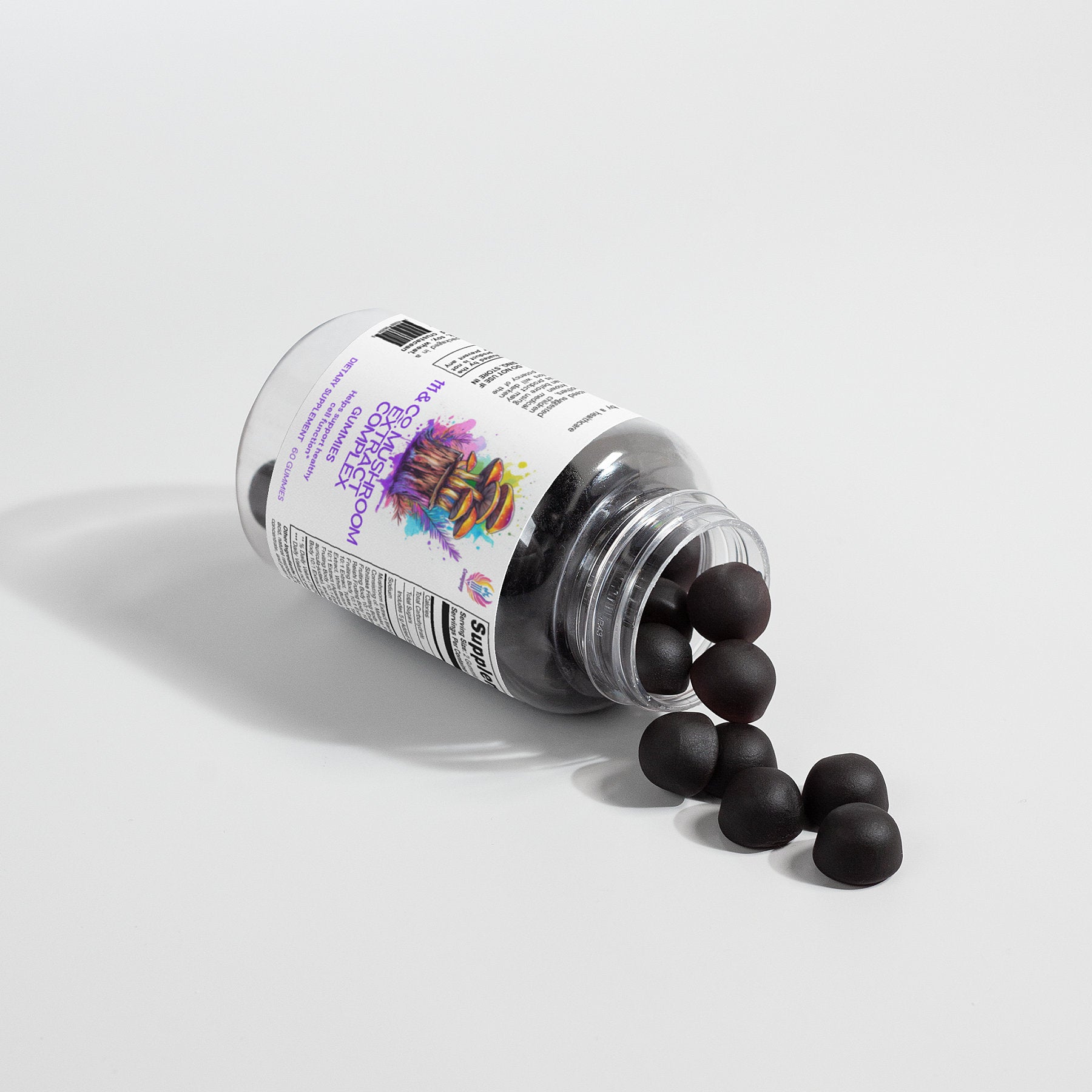 A transparent bottle labeled with 111 & COMPANY MUSHROOM COMPLEX GUMMIES rests on its side, scattering round, black gummies over a white surface. The label displays vibrant graphics and text, while shadows from the bottle and gummies enhance the simple, clean setup.