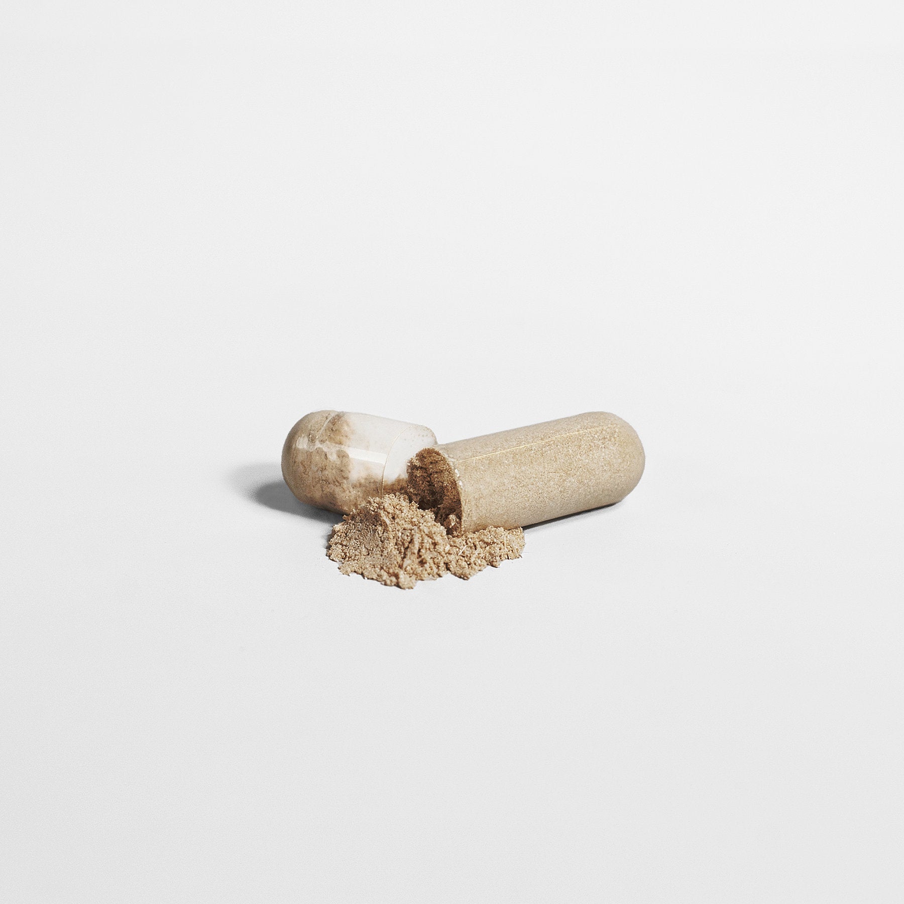 A partially open clear capsule of  111 & COMPANY NORMAL BLOOD SUGAR SUPPORT rests on a white surface, with brown granular powder spilling out next to it, symbolizing enhanced insulin sensitivity support.