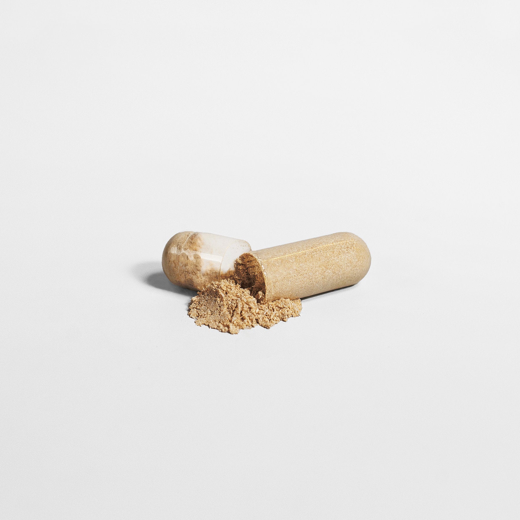 A 111 & COMPANY SLEEP FORMULA 111 & Company spills light brown Valerian Extract onto a white background. The transparent shell reveals the natural sleep formula, centrally placed to highlight its texture and minimalist design.
