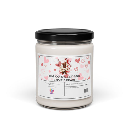 This 9oz soy wax candle by 111 & Company, labeled 111 & Company Sweet and Love Affair Cinnamon Vanilla, features a black lid. Its warm scent is ideal for cozy moments, with white wax against a plain background adorned with hearts and images of cinnamon sticks and vanilla flowers.