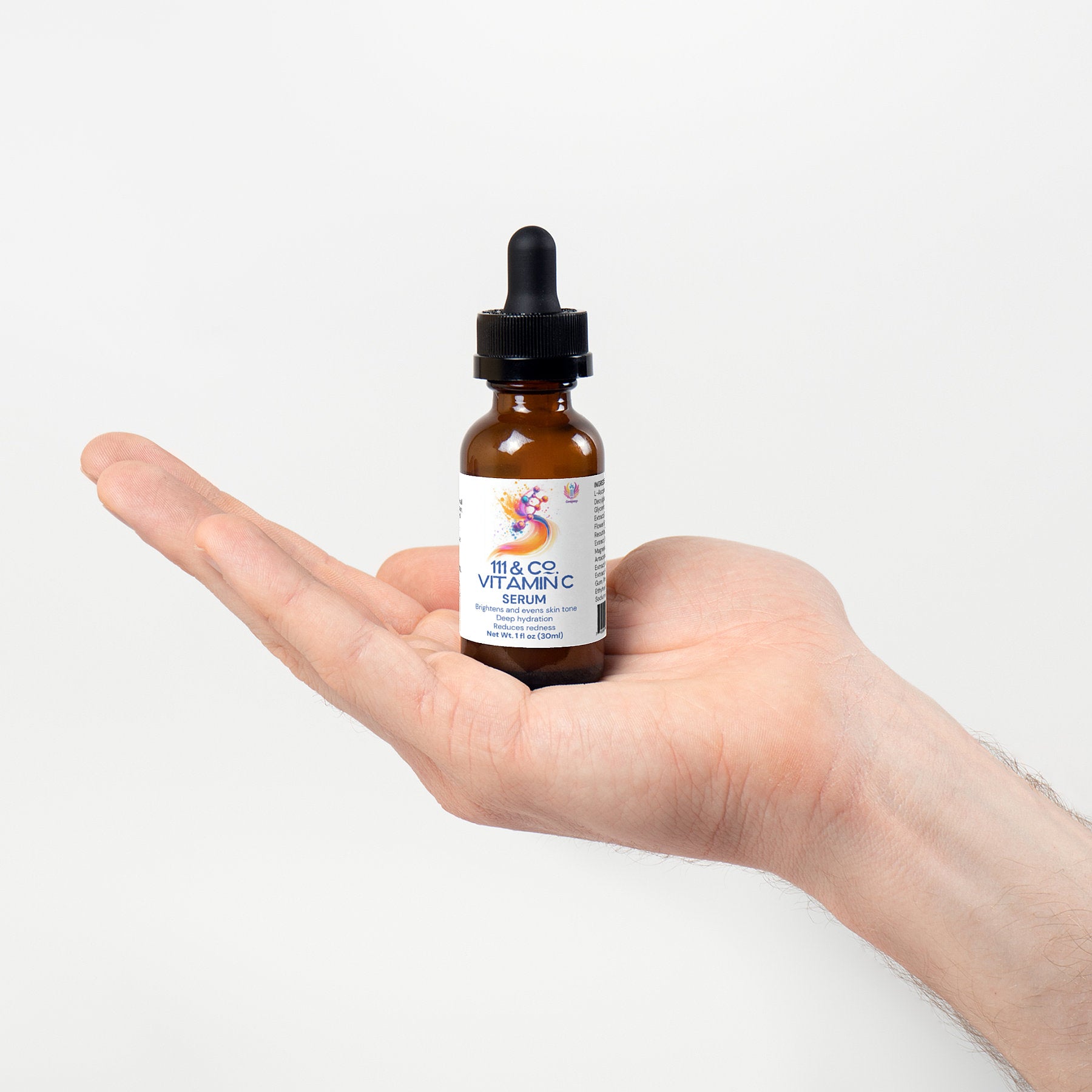 A hand is holding a small amber dropper bottle with a black cap against a plain white background. The label features colorful graphics and reads 111 & COMPANY VITAMIN C SERUM, by 111 & Company, highlighting its collagen-boosting properties. The palm faces upward.
