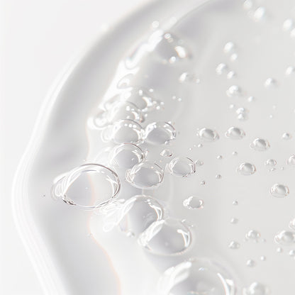 Close-up image of 111 & COMPANY WITCH HAZEL PORE PERFECTING TONER by 111 & Company: clear liquid gel with air bubbles forming organic patterns. Its glossy, smooth, and translucent texture reflects light against a plain white background, emphasizing purity and fluidity.