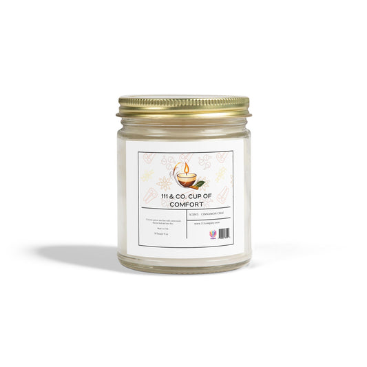 The Printify 111 & Company Cup of Comfort candle, labeled Cinnamon Chai, comes in a clear jar with an eco-friendly coconut apricot wax. The gold metal lid features icons like leaves and a steaming cup, promising an aromatic escape.