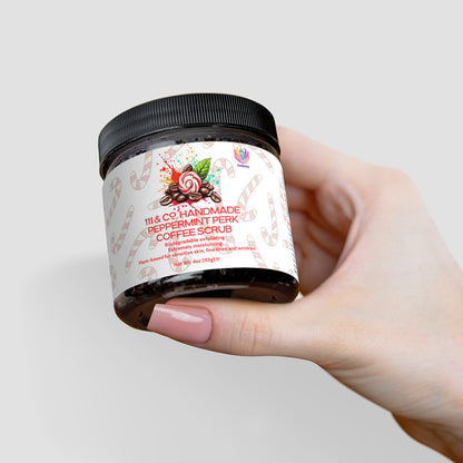 A hand with pale skin and manicured nails holds a jar of 111 & COMPANY HANDMADE PEPPERMINT PERK COFFEE SCRUB. The label features candy cane designs and a decorated coffee cup illustration. The jars lid is black, set against a light gray background, promising invigorating exfoliation.