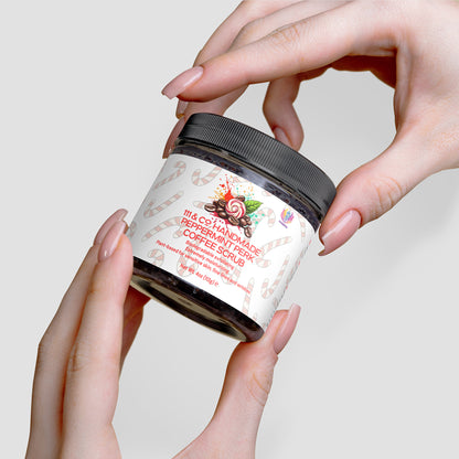 Hands cradle a jar of 111 & Companys 111 & COMPANY HANDMADE PEPPERMINT PERK COFFEE SCRUB. The 10 oz. label, featuring candy canes, peppermint swirls, and coffee beans against a cream backdrop, reveals an antioxidant-rich blend that exfoliates and enhances hydration and softness.