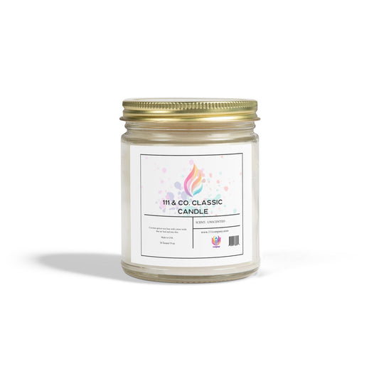 The 111 & COMPANY CLASSIC UNSCENTED CANDLE by Printify features a clear glass jar with a gold screw lid, adorned with a colorful flame logo and label. The candle contains eco-friendly coconut apricot wax (9oz), emitting a calming glow on a white background.