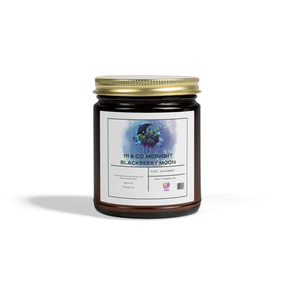 An amber jar candle with a gold lid, named 111 & Company Midnight Blackberry Moon Scented Candle, features blackberry and moon illustrations. Made from coconut apricot wax, it emits a fruity blackberry aroma. A plain white background with a left shadow enhances its elegant simplicity.